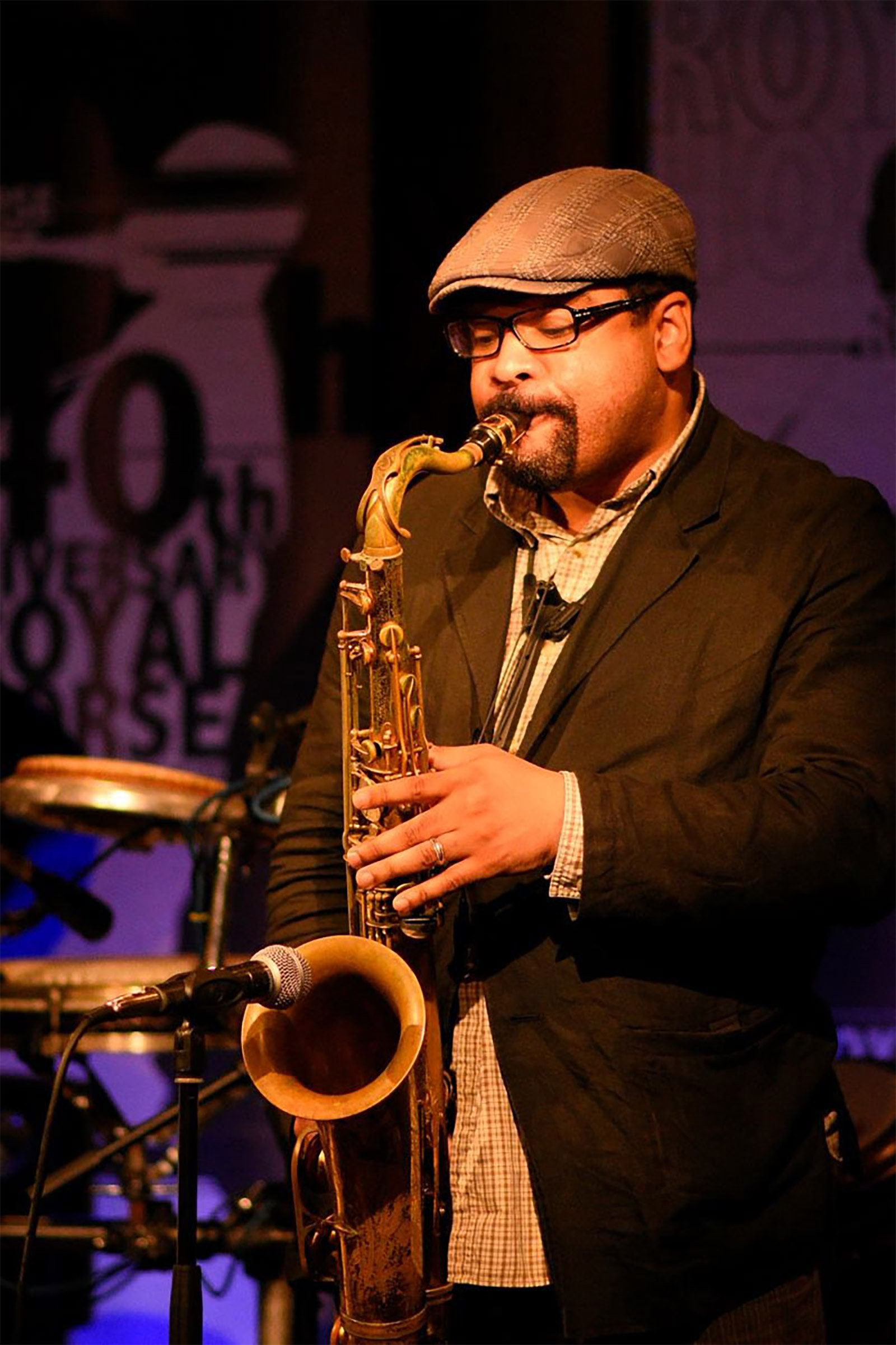 Tony Spruill performing live on tenor saxophone at a luxury hotel event.